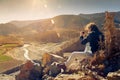 Young hiker enjoying sunset and taking picture