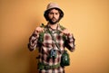 Young hiker man with curly hair and beard hiking wearing backpack and water canteen Pointing down looking sad and upset,