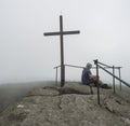 Young hiker man sitting on the top peak of Jizera mountain rock