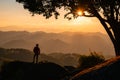 Young hiker man standing on top of mountain with the sun in the sunset Royalty Free Stock Photo