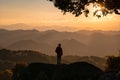 Young hiker man standing on top of mountain with the sun in the sunset Royalty Free Stock Photo