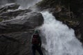 Young hiker stands in front of the Krimmler waterfalls