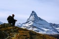 Young hiker taking a rest during trekking with the Matterhorn peak at the background.