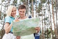 Young hiking couple reading map in forest Royalty Free Stock Photo
