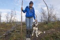 Young Hiking Woman With Happy Husky Trekking on a Path. Mixed Race Girl with Her Dog Walking in Forest. Royalty Free Stock Photo