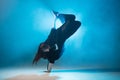 Young hip-hop female dancer performing solo on the stage in blue neon lights Royalty Free Stock Photo