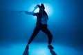 Young hip-hop female dancer performing solo on the stage in blue neon lights Royalty Free Stock Photo