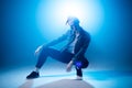 Young hip-hop female dancer performing solo on the stage in blue neon lights Royalty Free Stock Photo