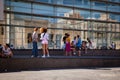Young hip people in front of modern building with glass facade, Barcelona