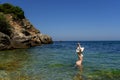 Young hippie beautiful nudist woman on the sea shore in summer time having relaxing time in water on o sunny day Royalty Free Stock Photo