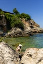 Young hippie beautiful nudist woman on the sea shore in summer time having relaxing time in water on o sunny day Royalty Free Stock Photo