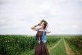 Young hippie woman with short red hair, wearing boho style clothes and flower wreath, running jumping on green field, smiling, Royalty Free Stock Photo