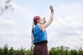 Young hippie woman with short red hair, wearing boho style clothes and sunglasses, dancing on green currant field, posing for Royalty Free Stock Photo