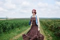 Young hippie woman with short red hair, wearing boho style clothes and sunglasses, dancing running jumping on green currant field Royalty Free Stock Photo
