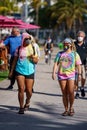 Young hippies walking in Miami Beach on Ocean Drive with tie dye shirts and face masks Royalty Free Stock Photo