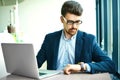 Young hipster businessman in cafe with notebook in suit