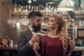 Young hipster couple in a cafe. He puts a fur on her shoulders, she is looking. Love or friendship concepts. Royalty Free Stock Photo