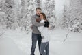 Young hipster couple hugs each other in a winter park. Winter holidays. Christmas holidays outdoors in the forest Royalty Free Stock Photo