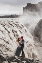 Young hipster couple in love kissing near famous Iceland Dettifoss waterfall Royalty Free Stock Photo