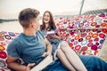 Young hipster couple reading books in a hammock at the beach at sunset, freelancer leisure man and woman on a beach trip, summer