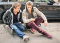 Young hipster fashion brothers having fun with smartphone