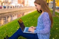 Young hipster girl in casual wear skilled lifestyle blogger typing article on modern laptop computer Royalty Free Stock Photo