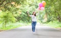 Young hipster girl holding balloon walk on the road, Royalty Free Stock Photo