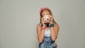 Young hipster girl holding retor insta polaroid camera taking photo portrait