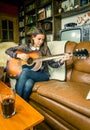 Young hipster girl playing acoustic guitar at home Royalty Free Stock Photo