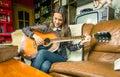 Young hipster girl playing acoustic guitar at home Royalty Free Stock Photo