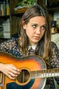 Young hipster girl playing acoustic guitar at home Royalty Free Stock Photo