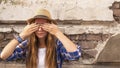 Young hipster girl standing in the street old town and closes his eyes his hands with colored nails.