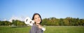 Young hipster girl, traveler holding her ukulele, playing outdoors in park and smiling Royalty Free Stock Photo