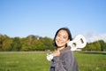 Young hipster girl, traveler holding her ukulele, playing outdoors in park and smiling Royalty Free Stock Photo