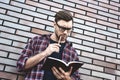 Portrait of handsome man in glasses and shirt isolated on brown brick wall Royalty Free Stock Photo