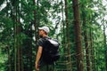 A young hipster man in casual clothes calls on the phone on a mountain hike  stands in the woods  communicates on a smartphone and Royalty Free Stock Photo