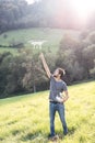 Young hipster man with flying drone. Sunny green nature. Royalty Free Stock Photo