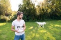 Young hipster man with flying drone. Sunny green nature. Royalty Free Stock Photo