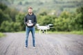 Young hipster man with flying drone. Sunny green nature. Royalty Free Stock Photo