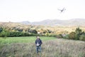 Young hipster man with flying drone. Sunny green nature. Royalty Free Stock Photo