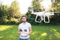 Young hipster man with flying drone. Sunny green nature. Royalty Free Stock Photo
