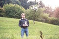 Young hipster man with flying drone. Sunny green nature. Royalty Free Stock Photo