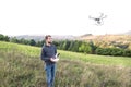 Young hipster man with flying drone. Sunny green nature. Royalty Free Stock Photo