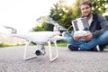 Young hipster man with flying drone. Sunny green nature. Royalty Free Stock Photo