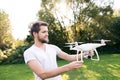 Young hipster man holding drone. Sunny green nature.