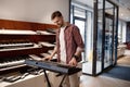 Young man pianist performing at music shop store playing on electric piano Royalty Free Stock Photo