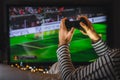 Young hipster man playing video game  football on console. gamer guy with gamepad controller holding in hands Wireless joystick si Royalty Free Stock Photo