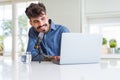 Young hipster man recording podcast using laptop, broadcasting an interview using microphone Royalty Free Stock Photo