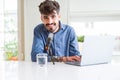 Young hipster man recording podcast using laptop, broadcasting an interview using microphone Royalty Free Stock Photo