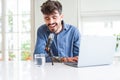 Young hipster man recording podcast using laptop, broadcasting an interview using microphone Royalty Free Stock Photo